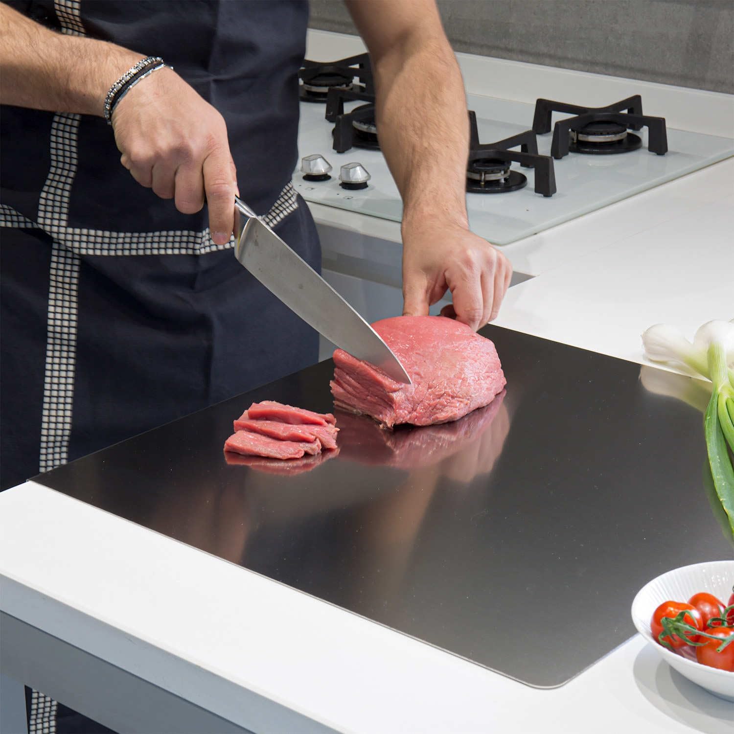Stainless Steel Cutting Board in use - slicing raw meat with knife on stainless steel surface
